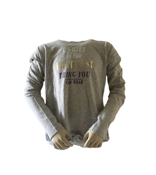 Shirt grijs met de tekst: Smile in the prettiest things you can ware. 100% katoen verkrijgbaar in de maten 140, 152 en 164.
