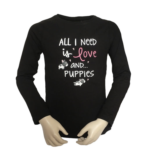 Shirt zwart met twee puppies die door de tekst: All you need is love and... puppies lopen. 100% katoen en verkrijgbaar in de maten 92 t/m 128.